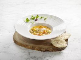 Braised Supreme Birds Nest with Crab Roe served in a dish on wooden board side view on grey marble background photo
