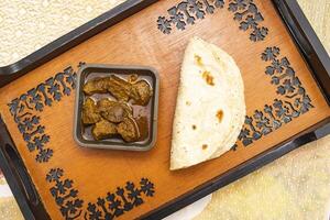 Beef curry with Roti served on tray dish isolated on dinning table top view of bangladeshi food photo