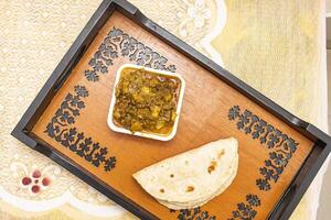 Beef Bot Curry with Roti served on tray dish isolated on dinning table top view of bangladeshi food photo