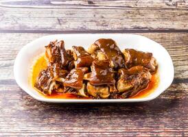 Sichuan Wine Pork Knuckle served in tray dish isolated on wooden table side view of hong kong food photo