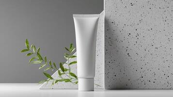 Mockup of cosmetic tube cream 50ml on concrete stone stand on gray background minimalist with green leaves. No branding, label template. Natural hard lighting and shadows photo