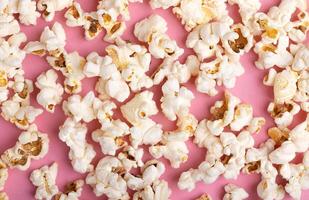 Popcorn on Pink Background. Snack when watching a movie. Flat lay with copy space photo