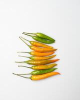 yellow red orange chili peppers lie on a white background photo