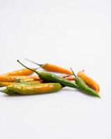 yellow red orange chili peppers lie on a white background photo