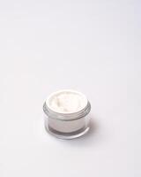 white jar with cream on a white background photo