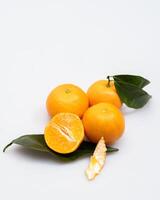 oranges and tangerines with leaves whole and in size lie on a white background photo