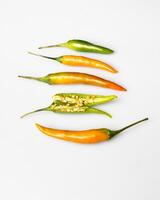 yellow red orange chili peppers lie on a white background photo