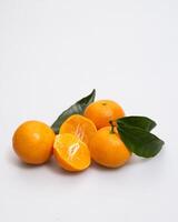 oranges and tangerines with leaves whole and in size lie on a white background photo