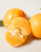 oranges and tangerines with leaves whole and in size lie on a white background photo