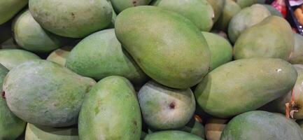 Pile of fresh mango fruits background ready to sale on the supermarket photo