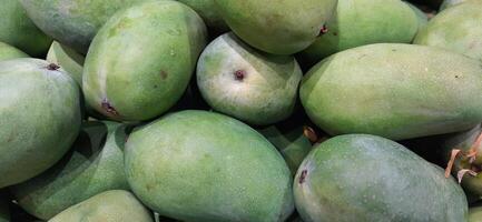 Pile of fresh mango fruits background ready to sale on the supermarket photo