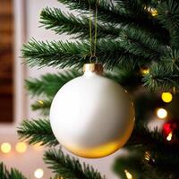 Large Christmas decoration, shiny white bauble hanging on tree surrounded by fluffy pine branches. photo
