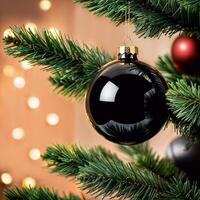 Large Christmas decoration, shiny black bauble hanging on tree surrounded by fluffy pine branches. photo