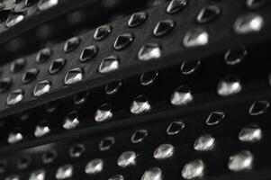 leather and metal abstract background with patches of black bullskin and shiny metal rivets in the style of bikers and rocknroll lovers of the 80s and 90s. High quality photo