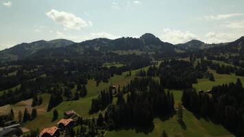 Drone of the Swiss Alps, flying through a lush, forested green valley. The footage showcases woodlands, rolling terrain, and mountains. video