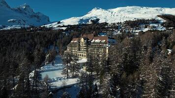 Aerial view over St. Moritz, Switzerland during winter with snow covered mountains in the background. video