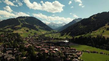 Timeless summer scene of valley and village in swiss alps. Gstaad, switzerland. Drone aerial view 4k. video