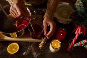 Preparing Hot Mulled Wine with Christmas Decorations and Candles photo