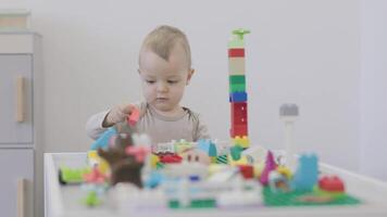 Toddler joyfully engaging with colorful building blocks while constructing and arranging them video