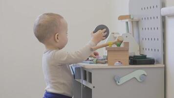 Toddler engaging with colorful toy tools at a play workbench video