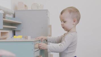 Toddler engaging in imaginative play with a colorful toy kitchen set video
