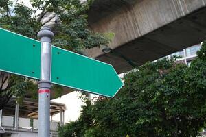 Blank right pointer directional arrows signpost on the side of the road. green sign mock up template. photo