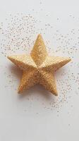 Decorative golden star surrounded by sparkling glitter on a light background photo