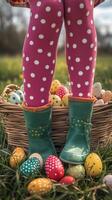 Colorful eggs surround a child wearing polka dot leggings in a garden on a sunny day photo