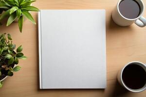 Blank notebook positioned between two coffee cups with plants on a wooden table photo