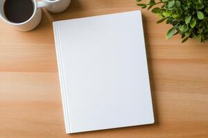 Blank notebook positioned between two coffee cups with plants on a wooden table photo