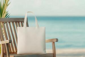 White tote bag resting on a wooden table near the beach with calm water and clear sky photo
