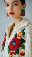 Young woman showcases colorful floral sweater in studio setting with soft lighting photo