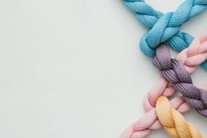 Various pastel colored threads woven together creating an artistic arrangement on a white background photo