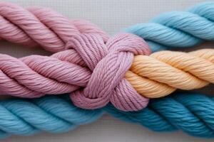 Various pastel colored threads woven together creating an artistic arrangement on a white background photo