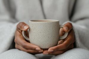 Warm beverage held in hands, cozy moment captured at home on a chilly day photo