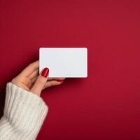 Person holding a blank card with red background and cozy sweater photo