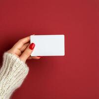 Person holding a blank card with red background and cozy sweater photo