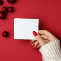 Person holding a blank card with red background and cozy sweater photo