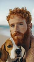 Red haired man with freckles and his beagle dog in a natural outdoor setting photo