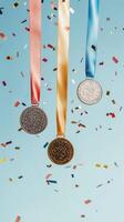 Medals hang against a blue background with confetti celebrating achievement photo