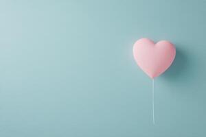 Pink heart shaped piece broken on a light blue background representing love and relationships photo