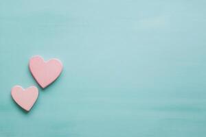 Pink heart shaped piece broken on a light blue background representing love and relationships photo
