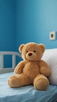 Soft bear sitting on a bed in a cozy blue room with calming atmosphere photo