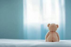 Soft bear gazing out a bright window in a serene bedroom setting photo