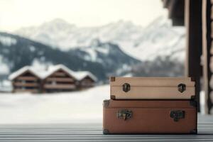 Stacked vintage suitcases on wooden deck with snowy mountains in the background photo