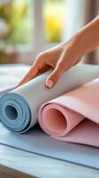 Hand unrolling pastel colored craft paper on a wooden surface during a creative project photo