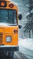 Bright yellow bus parked on a snowy road surrounded by tall trees in winter photo