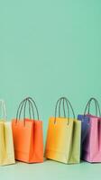 Colorful shopping bags arranged on a green backdrop for a vibrant retail display photo