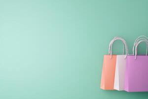 Colorful paper shopping bags resting against mint green background photo