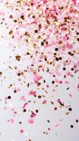 Colorful confetti made of pink petals and gold flakes falling gracefully from above photo